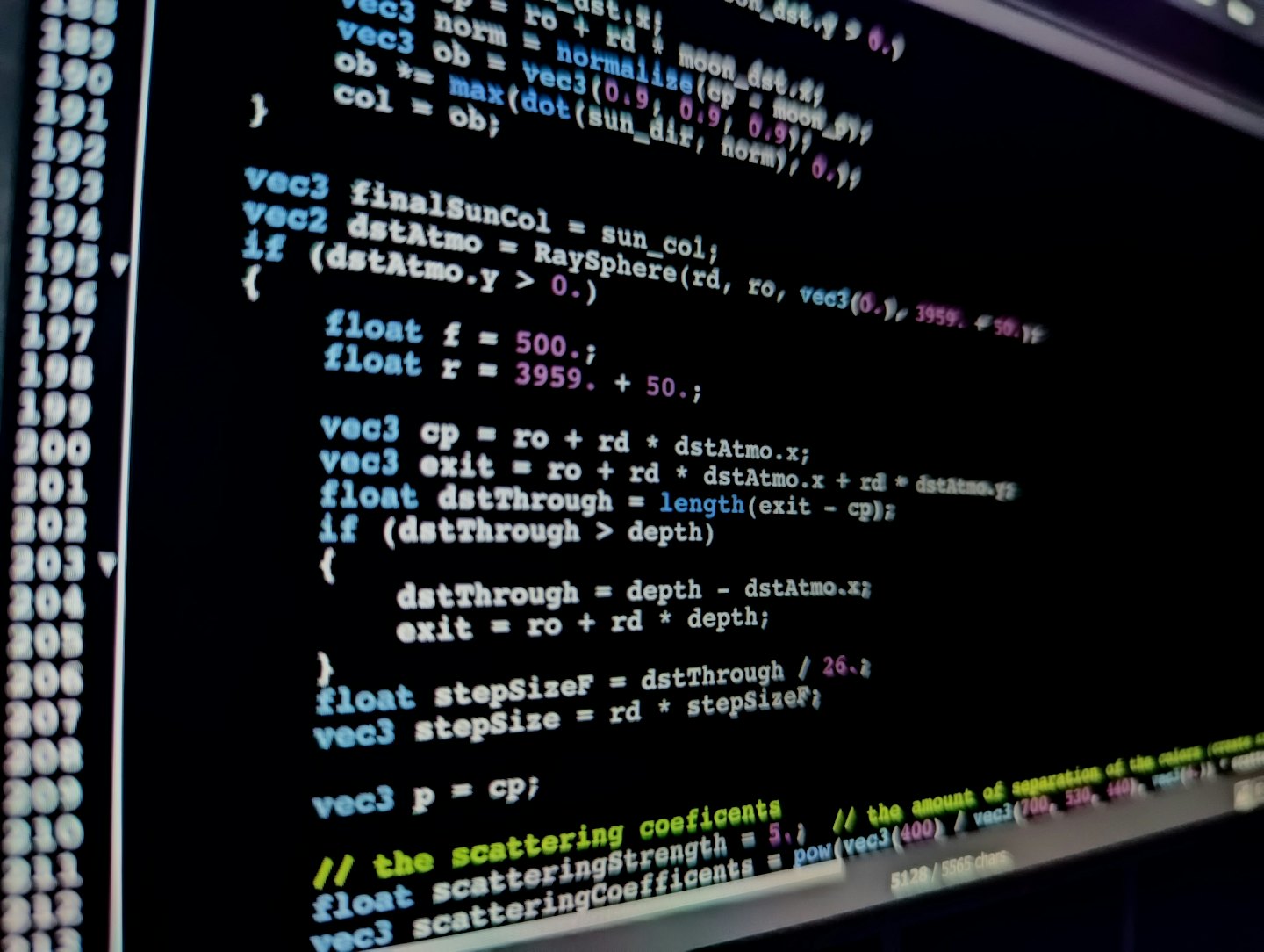Codice informatico colorato che brilla su uno schermo scuro.